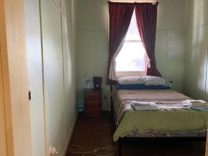 a small room with a bed and a window at Lockhart Railway Hotel in Lockhart