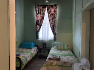 a small room with two beds and a window at Lockhart Railway Hotel in Lockhart