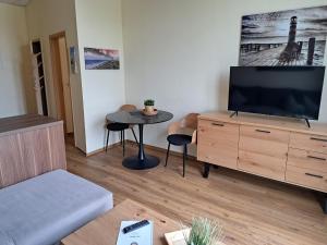 a living room with a flat screen tv and a table at Kühlungsborner Brauhaus in Kühlungsborn