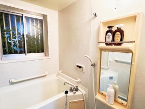 un bagno con vasca, lavandino e finestra di 池袋電車2分3Room 6人可 a Tokyo