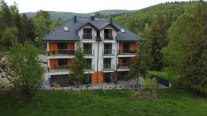 a house in the middle of a hill with trees at Apartamenty Trzy Kopce SKI & BIKE & SAUNA in Ustroń
