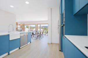 a kitchen with blue cabinets and a table with chairs at Refúgio da Garça in Chaves