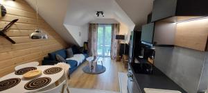 a kitchen and living room with a couch and a table at Apartamenty Trzy Kopce SKI & BIKE & SAUNA in Ustroń