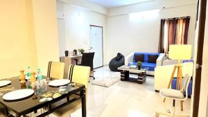 sala de estar con mesa y sofá azul en HOTEL NAMAHA, en Shamshabad