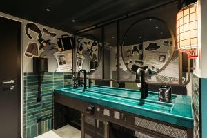 ein Badezimmer mit zwei Waschbecken und zwei Spiegeln in der Unterkunft Hotel Schani UNO City in Wien