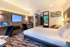 um quarto de hotel com uma cama e uma TV de tela plana em Nemea Appart Hotel Concorde Toulouse Gare Matabiau em Toulouse