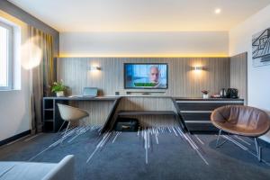 Uma televisão e/ou sistema de entretenimento em Nemea Appart Hotel Concorde Toulouse Gare Matabiau