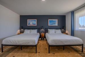 two beds in a room with blue walls at The Inn at Shady Pines in Gros Cap