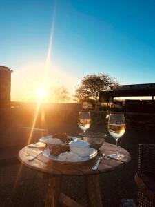 a table with a plate of food and two glasses of wine at Kitchen51 Cottages in Keetmanshoop