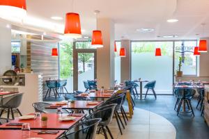 un restaurante con mesas, sillas y luces rojas en Nemea Appart Hotel Concorde Toulouse Gare Matabiau en Toulouse