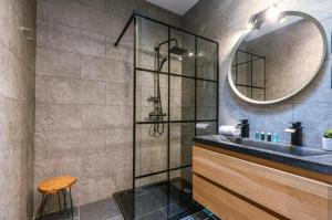 een badkamer met een douche met wastafel en spiegel bij loftlivinq@sea in Middelkerke +34 foto's