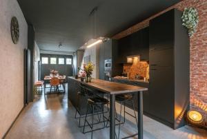 een keuken met een tafel en een bakstenen muur bij loftlivinq@sea in Middelkerke