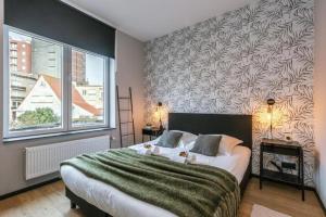een slaapkamer met een groot bed en een groot raam bij loftlivinq@sea in Middelkerke