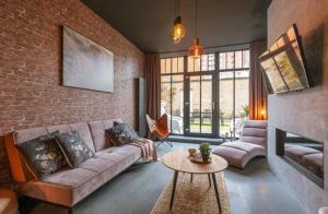 een woonkamer met een bank en een bakstenen muur bij loftlivinq@sea in Middelkerke
