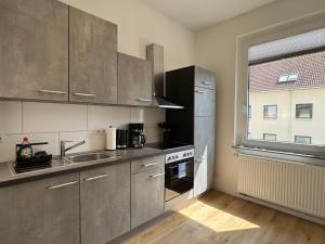 a kitchen with stainless steel appliances and a window at Kaiser Apartment am Meer 1 in Wilhelmshaven