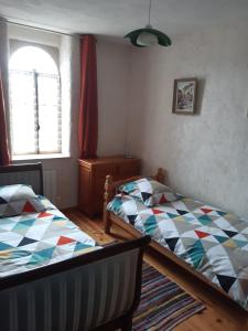a bedroom with two beds and a window at La chanvriere in Manheulles