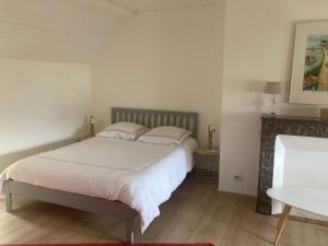 - une chambre avec un lit doté de draps et d'oreillers blancs dans l'établissement Le logis du Vassal, à Laval