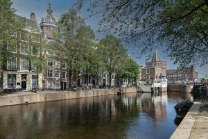 einen Kanal in einer Stadt mit Gebäuden und einem Boot in der Unterkunft The Sixteen in Amsterdam