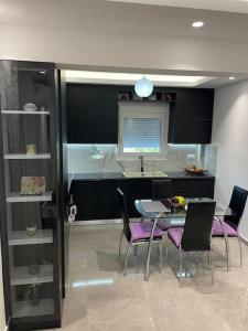 una sala da pranzo con tavolo e sedie e una cucina di Dragoti a Leptokarya