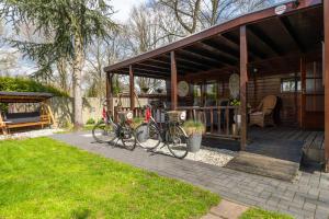 dos bicicletas estacionadas frente a una cabaña en Drents Genieten - Struikheide met privé whirlpool, en Erm