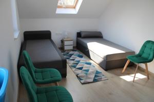 a room with two beds and two green chairs at Bałtyckie domki Kopalino in Kopalino