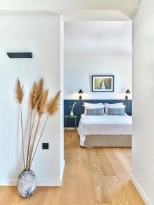 um quarto com uma cama e um vaso com uma planta em Magoo Suites em Logaras
