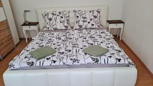 a bed with a black and white comforter and two night stands at Haus Piroschka in Mörbisch am See