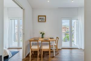 a dining room with a table and chairs and windows at Centrally located apartments, free parking in Trogir