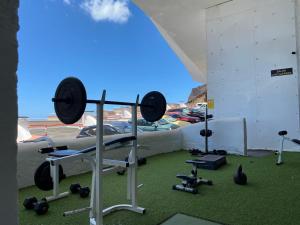 Habitación con gimnasio, cama y pesas en Apartamentos playa chica / playa las gaviotas, en Santa Cruz de Tenerife