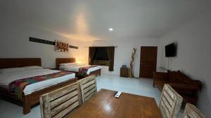 1 dormitorio con 2 camas, mesa y sillas en Lakey Peak B and B en Huu