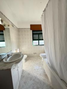 a bathroom with a sink and a shower curtain at Hotel Trindade Coelho in Mogadouro