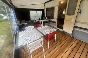 a dining table and chairs in an rv at Dębki przyczepa kempingowa Fendt in Dębki +1 photo