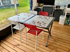 a table and four chairs sitting on a deck at Dębki przyczepa kempingowa Fendt in Dębki