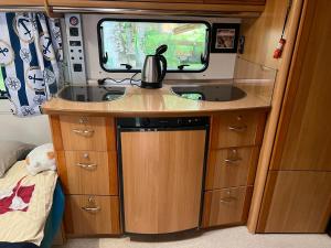 a kitchen in an rv with a sink at Dębki przyczepa kempingowa Fendt in Dębki