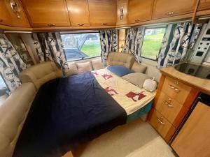 a bed in the back of a camper van at Dębki przyczepa kempingowa Fendt in Dębki