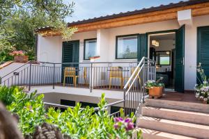 a home with a deck with yellow chairs at Hotel Baia Del Capitano in Cefalù