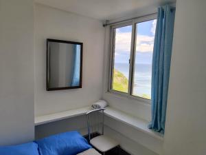 um quarto com uma janela com um espelho e uma cama em Playa dorada em Pampatar