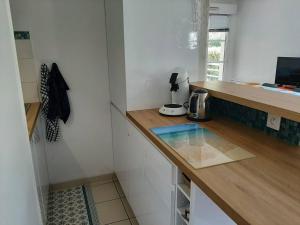 Una cocina con una encimera y una cafetera encima. en Résidence AMARINE- Appartement avec terrasse couverte pour 3 personnes, en Hossegor 2 fotos más