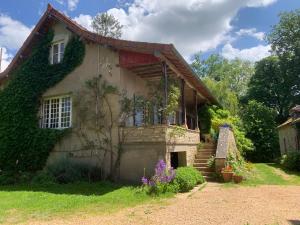 a house with ivy growing on the side of it at Les Jardins d'Ayaël in Ozenay