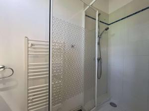 La salle de bains est pourvue d'une douche avec une porte en verre. dans l'établissement Appartement La Rochelle, 1 pièce, 2 personnes - FR-1-246-687, à La Rochelle
