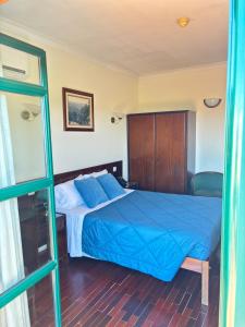Schlafzimmer mit einem Bett mit blauer Decke in der Unterkunft Hotel Trindade Coelho in Mogadouro