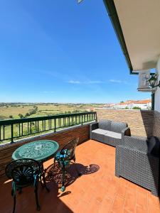 einen Balkon mit einem Tisch, Stühlen und einem Sofa in der Unterkunft Hotel Trindade Coelho in Mogadouro