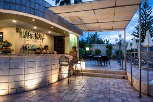 a bar on a patio with a person sitting at it at Hotel Baia Del Capitano in Cefalù