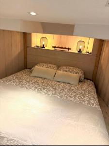 Cette chambre comprend un grand lit et 2 lampes murales. dans l'établissement Het Waterhotel, à Heerenveen