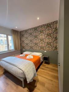 a bedroom with two beds and a wall at PIO X Apartments Treviso in Treviso