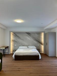 een slaapkamer met een bed en een schilderij aan de muur bij Albergo Panorama in Malesco