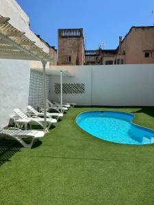 埃爾阿雷納爾的住宿－Casthotels Leblon，庭院里设有一组椅子和一个游泳池