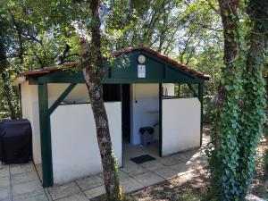 a building with a green roof next to a tree at N5 Emplacement tente van camping-car in Saint-Aubin-de-Nabirat +4 photos