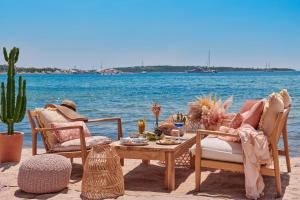 einen Tisch und Stühle am Strand mit Wasser in der Unterkunft Hôtel Barrière Le Majestic Cannes in Cannes