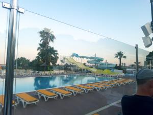 a swimming pool with lounge chairs and a roller coaster at Mobil Home dans camping Lattes in Lattes